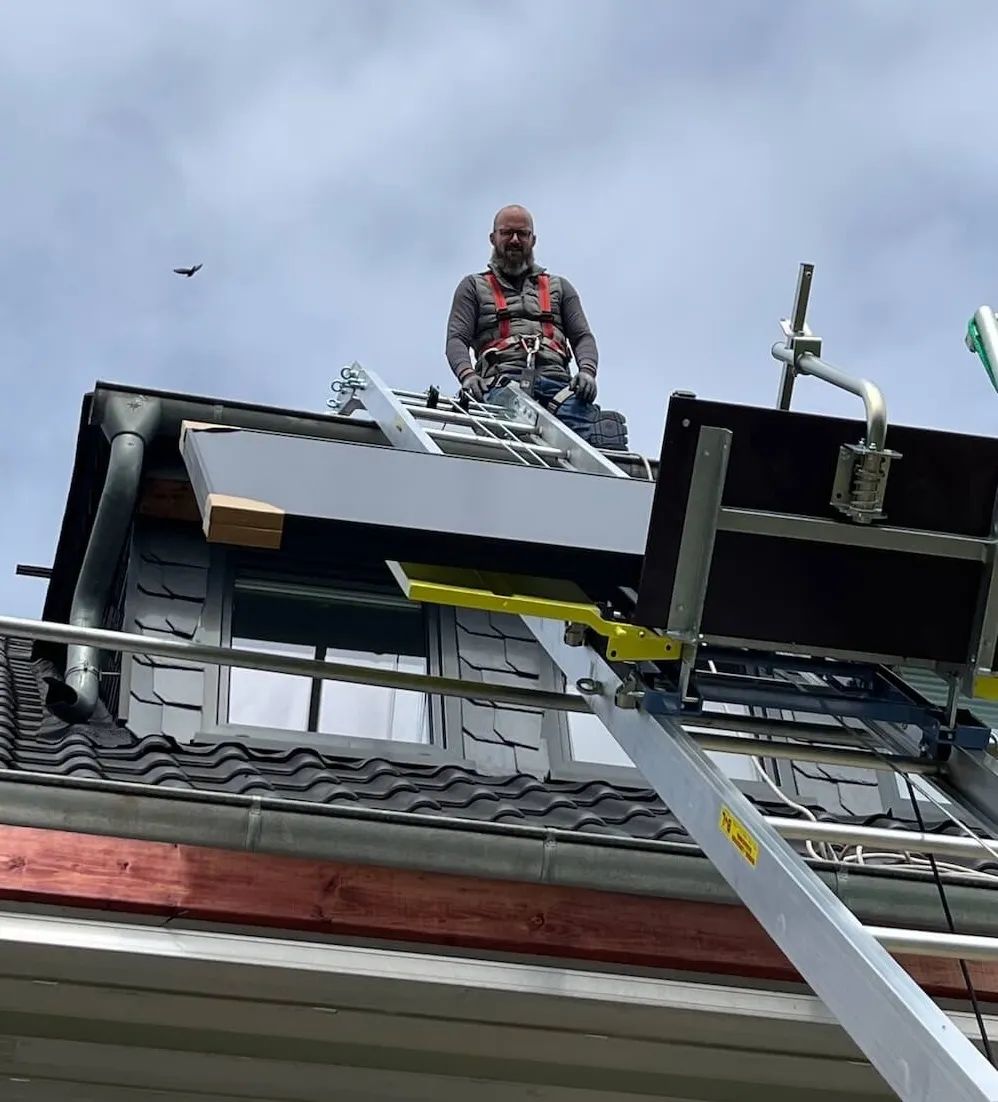 Elektromeister bei der Montage einer Photovoltaikanlage auf dem Dach